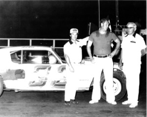 Arnie Braland (center) is shown joining fellow Kossuth County Racing Hall of Fame members in victory lane at Alta. Joining Braland is flagman Larry Cook (left) and track promoter Dick Simpson. (photo courtesy of Dean Simpson family)