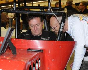 Terry McCarl sits behind the wheel of his first sprint car. Daryl Arend looks on. 